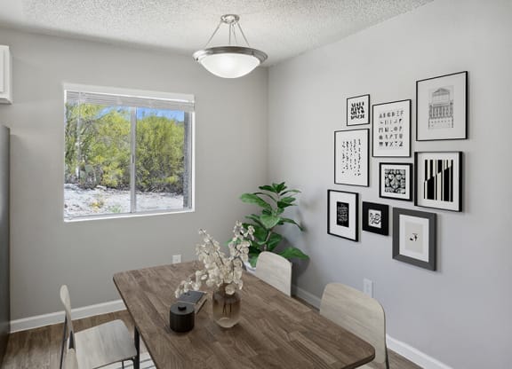 Model Dining Room with Wood-Style Flooring and Window View at Hilands Apartments in Tucson, AZ.