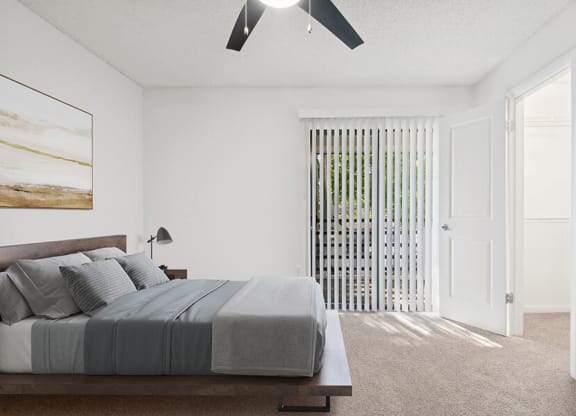 Model Bedroom with Carpet, Walk In Closet & Patio Accessibility at Rosehill Preserve Apartments located in Orlando, FL.