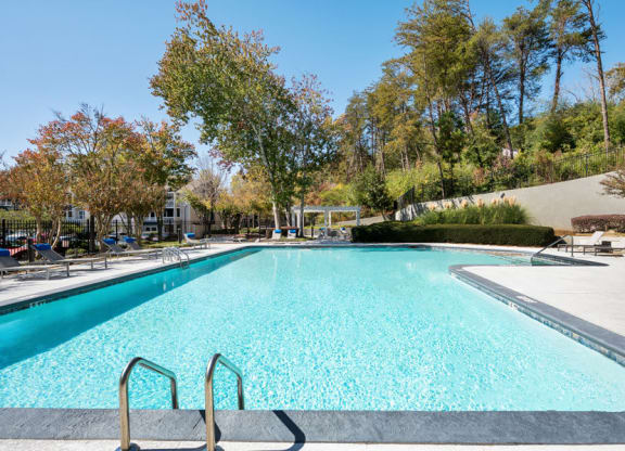 One-Bedroom Apartments in Sandy Springs, GA - Edgewater at Sandy Springs - Resort-Style Swimming Pool With Wide Sundeck, Lounge Chairs, And Tree-Lined Views Under The Sky.