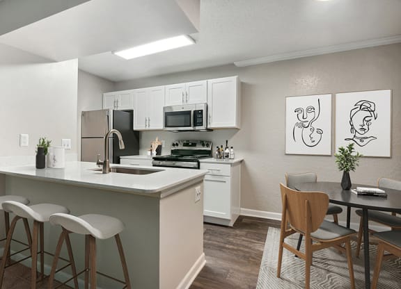 Model Dining Room and Kitchen Area with Wood-Style Flooring at Arbor Village Apartments in Charlotte, NC.