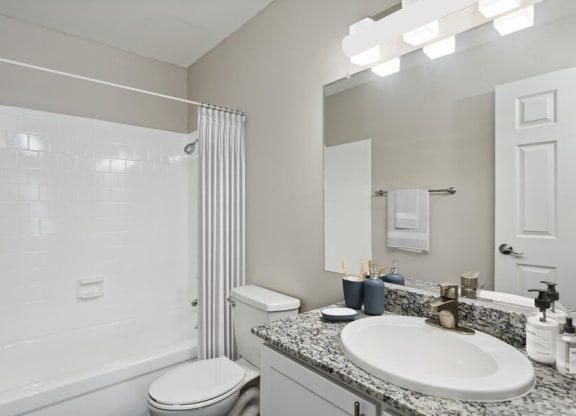 Model bathroom with a sink, toilet, and tub/shower