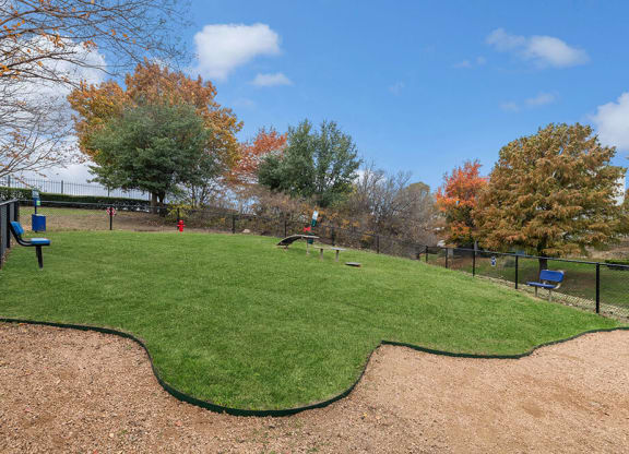 Community Dog Park with Agility Equipment at Bridges at Oakbend Apartments in Lewisville, TX.