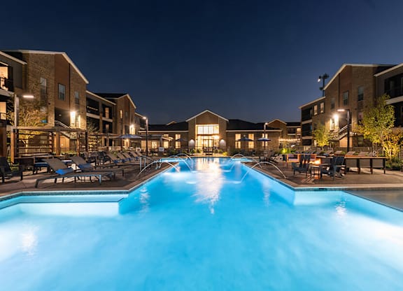 Community Swimming Pool with Pool Furniture at Alta 3Eighty Apartments located in Aubrey, TX.