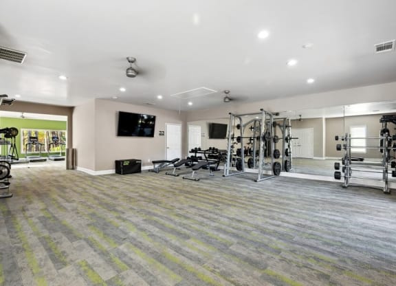 Three-Bedroom Apartments in Norcross, GA- Elevate at Jackson Creek - Fitness Center With Weight Machines, Free Weights, Benches, Wall Mirrors, And Cardio Equipment In Bright Open Room