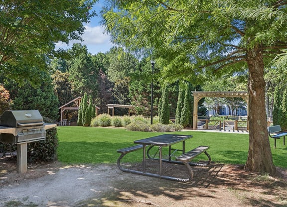 Outdoor BBQ Area with Picnic Table at Lakeside Retreat Apartments located in Peachtree Corners, GA.