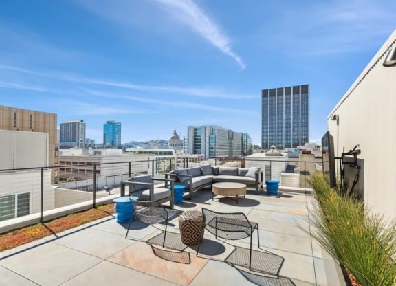Rooftop lounge space with large TV and chairs at TL Residences