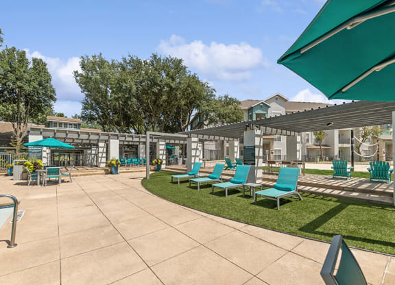 Community Swimming Pool with Pool Furniture at Essence Apartments in Dallas, TX.