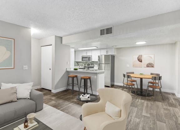 Model Living Room and Kitchen/Dining Room Area with Wood-Style Flooring at Meadow Ridge Apartments in Las Vegas, NV.