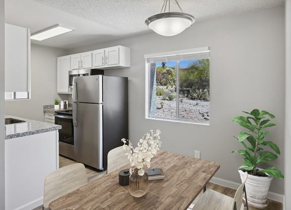 Model Dining Room with Wood-Style Flooring & View of Kitchen at Hilands Apartments in Tucson, AZ.