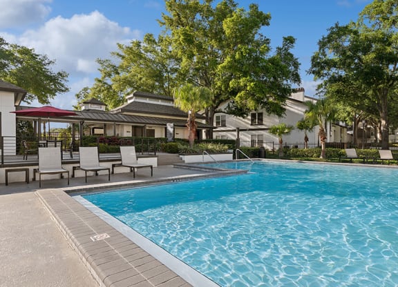 Community Swimming Pool with Pool Furniture at Rosehill Preserve Apartments located in Orlando, FL.