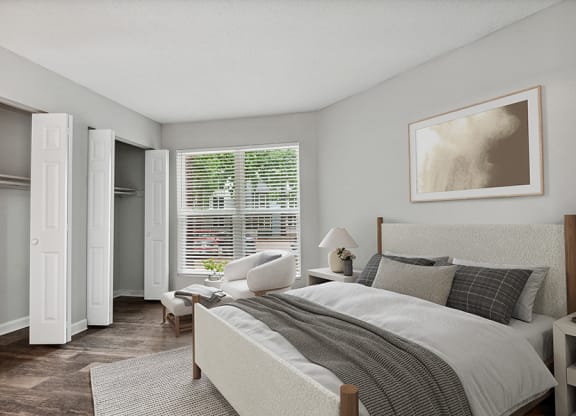 Model Bedroom with Double Closets and Wood-Style Flooring at Arbor Village Apartments in Charlotte, NC.