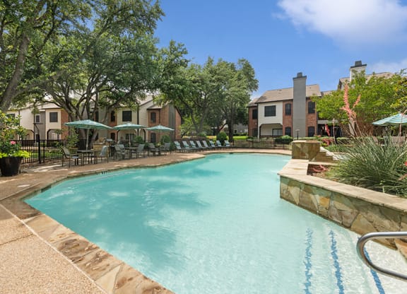 Community Swimming Pool with Pool Furniture at Dallas North Park Apartments in Dallas, TX.