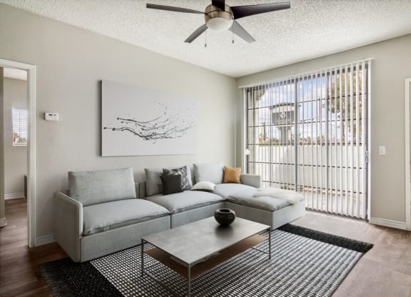 a living room with a couch coffee table and a ceiling fan