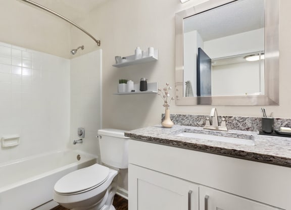 Model Bathroom with White Cabinets, Wood-Style Flooring and Shower/Tub at Grandstand Apartments in Marietta, GA.