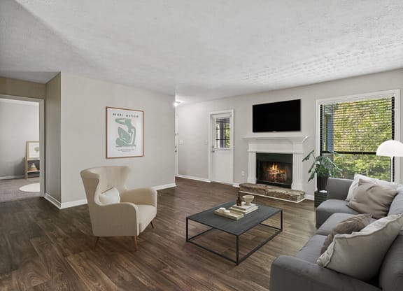 Model Living Room with Wood-Style Flooring and Fireplace at Lakeside Retreat Apartments located in Peachtree Corners, GA.