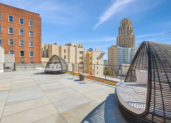 Rooftop lounge space with large pod chairs at TL Residences