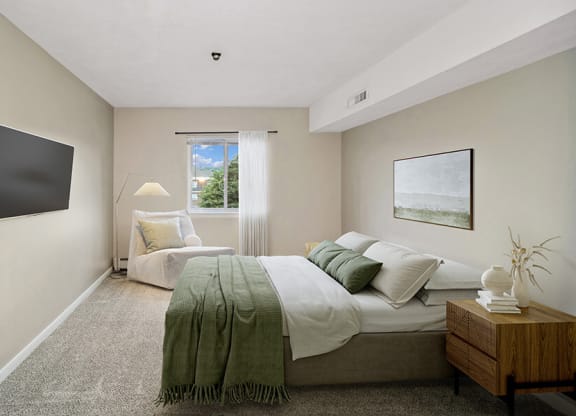 Model bedroom with a bed and a window at Stone Ends apartments in Stoughton, MA