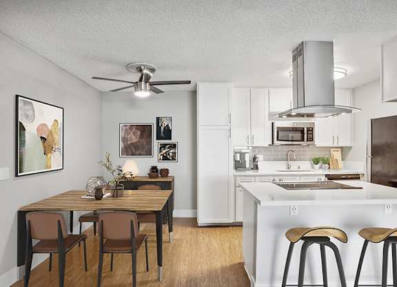 Model Kitchen with White Cabinets and Wood-Style Flooring at Cove La Mesa Apartments located in La Mesa, CA.