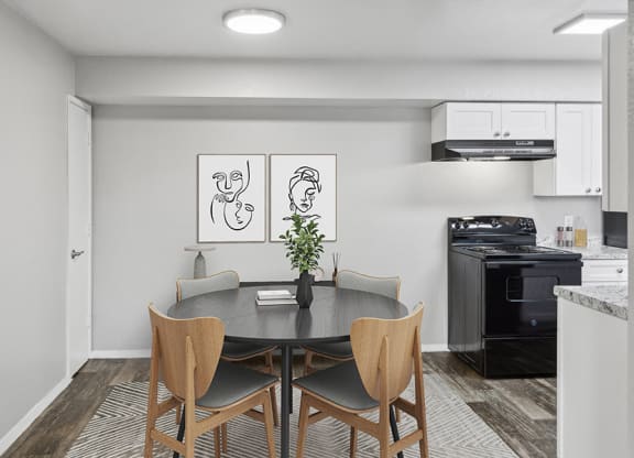 Model Dining Room with Wood-Style Flooring and View of Kitchen at Tanque Verde Apartments located in Tucson, AZ.