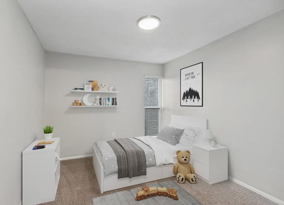 Model Bedroom with Carpet and Window View at Parc at Creekside Apartments in Kansas City, MO.