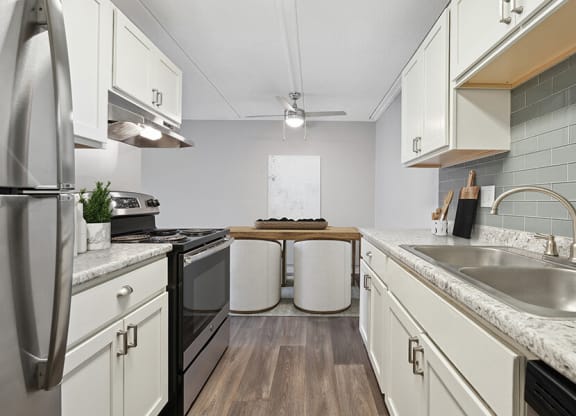 Model Kitchen with White Cabinets and Wood-Style Flooring at Elevate on Parkway, Burnsville, Minnesota