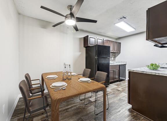 Model Dining Room and Kitchen Area with Wood-Style Flooring at Paramont Apartments in Duluth, GA.