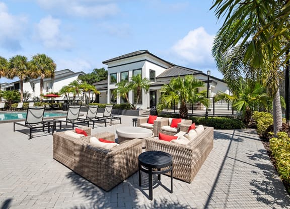Outdoor Lounge Area with Furniture and View of Pool at Rosehill Preserve Apartments in Orlando, FL.