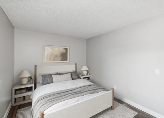 a bedroom with white walls and a bed with a gray blanket