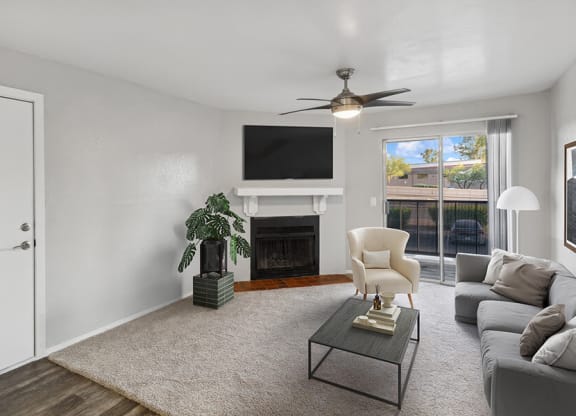Model Living Room with Wood-Style Flooring, Fireplace and Patio Accessibility at Tanque Verde Apartments located in Tucson, AZ.
