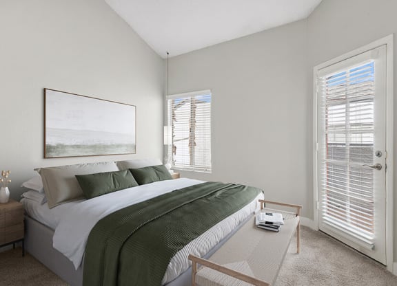 Model Bedroom with Carpet and Patio Accessibility at Crystal Creek Apartments in Phoenix, AZ.