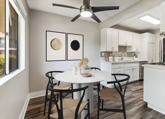Model Dining Room with Wood-Style Flooring, One Window & View of Kitchen at Forest Park Apartments in El Cajon, CA.