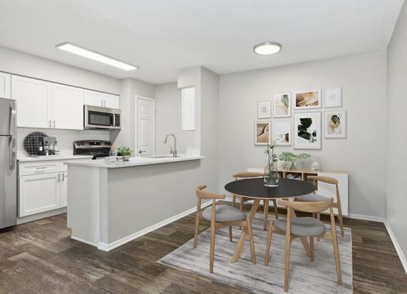 Model Dining Room and Kitchen Area with Wood-Style Flooring at Grand Pavilion Apartments in Tampa, FL.