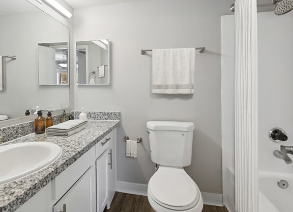 Model Bathroom with Wood-Style Flooring at Hilands Apartments in Tucson, AZ.