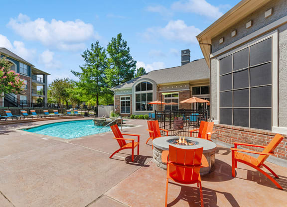 Outdoor Fire Pit Area with Lounge Furniture and Pool View at Belmont at Duck Creek Apartments in Garland, TX.