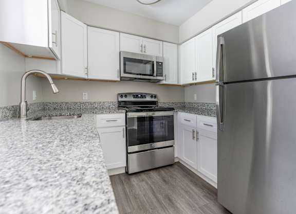 A modern kitchen with a stainless steel refrigerator and oven.