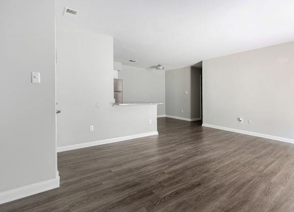 A room with wooden flooring and white walls.