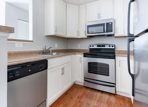 A kitchen with white cabinets and a black stove top oven.