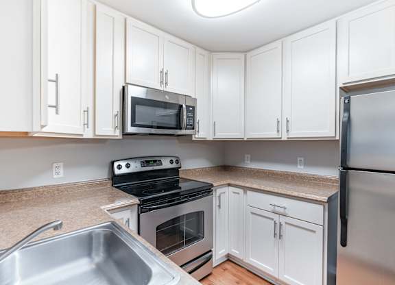 A kitchen with white cabinets and stainless steel appliances.