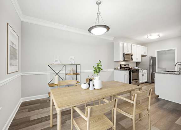 Model Dining Room with Wood-Style Flooring and View of Kitchen at Dulles Green Apartments located in Herndon, VA.