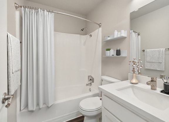 Model Bathroom with White Cabinets, Wood-Style Flooring and Shower/Tub at Colonnade at Fletcher Hills Apartments in El Cajon, CA.