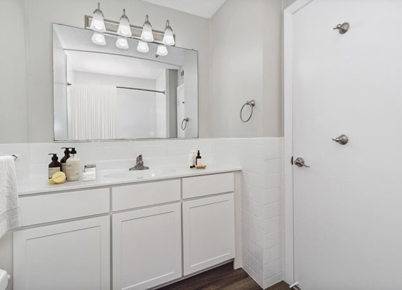Model bathroom with a sink and a mirror  at Stone Ends apartments in Stoughton, MA