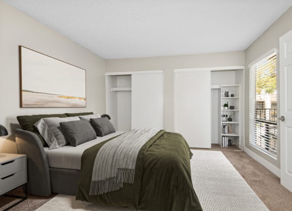 Model apartment bedroom with a large bed and a large window at Villages at Metro Center, Arizona