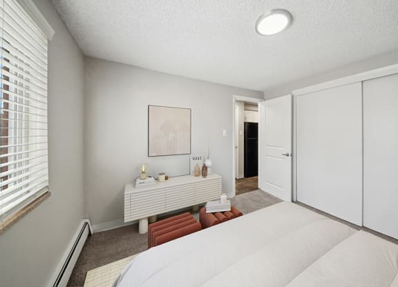 Model Bedroom with Carpet and Closet at Esprit at Cherry Creek Apartments in Glendale, CO.