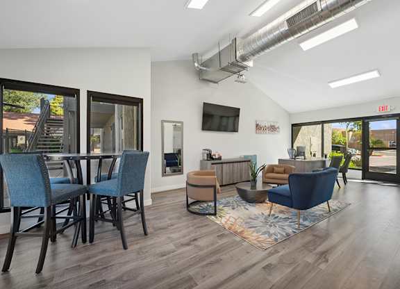 A modern living room with a blue chair and a brown ottoman.