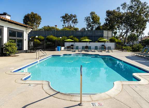 A large outdoor swimming pool with a diving board.