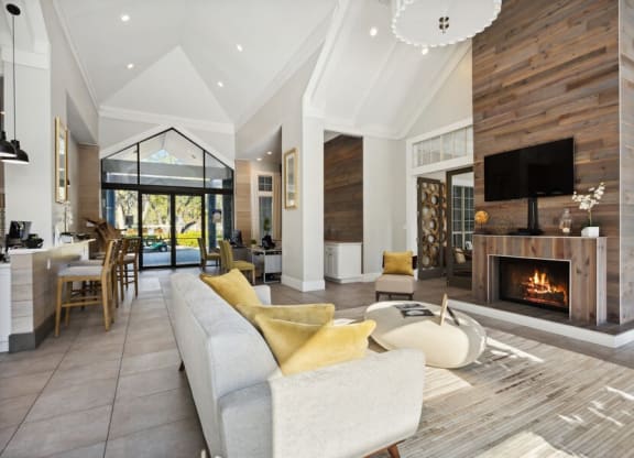 Clubhouse Lounge Area with Fireplace and View of Kitchen at Caribbean Breeze Apartments in Tampa, FL.