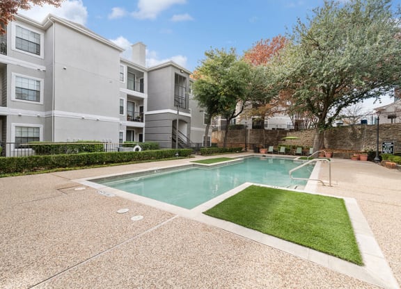 Community Swimming Pool with Pool Furniture at Bridges at Oakbend Apartments in Lewisville, TX.