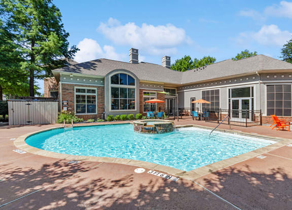 Community Swimming Pool with Pool Furniture at Belmont at Duck Creek Apartments in Garland, TX.