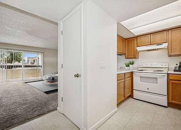 Model Classic Kitchen with Tile Flooring and View of Living Room at Butler Ridge Apartments located in Glendale, AZ.