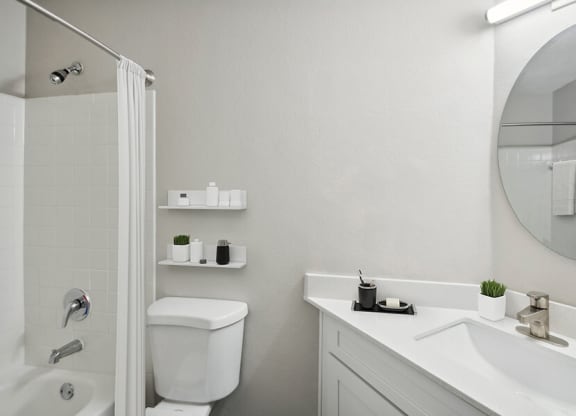Model Bathroom with White Cabinets, Wood-Style Flooring & Shower/Tub at Arbor Village Apartments located in Charlotte, NC.